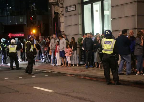 Guests from the Premier Inn Bankside Hotel are evacuated and kept in a group with police on Upper Thames Street following the terrorist incidents on London Bridge and Borough Market