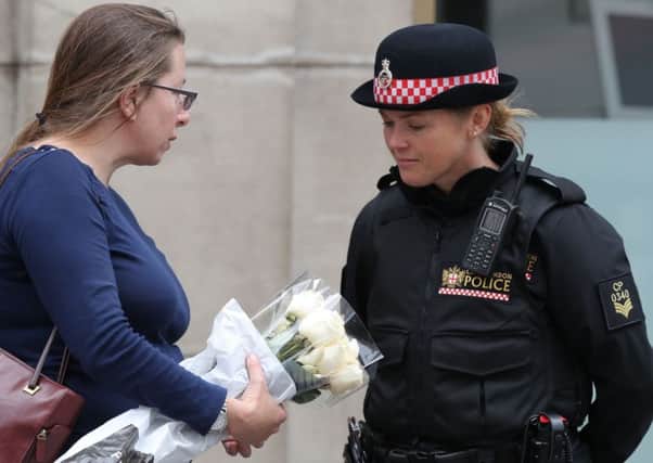 A member of the public speaks to a police officer as she brings flowers to lay on the north side of London Bridge following last night's terrorist incident. PRESS ASSOCIATION Photo. Picture date: Sunday June 4, 2017. See PA story POLICE Bridge. Photo credit should read: Andrew Matthews/PA Wire