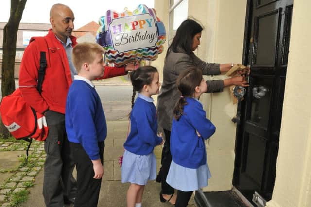 Photo Neil Cross
Postie Asim Raza delivers a surprise gift to Azra Butt of Eldon Primary School, with Kelvin Stuttard, Lainee Cavis and Jasmine Corley, in the form of keys to the school's new house