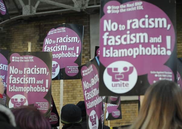 UAF supporters hold up placards during demonstrations by the EDL and the Unite Against Fascism groups in Preston