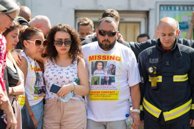 Fighfighters and members of the public at Latymer Community Centre observe a minute's silence near to Grenfell Tower in west London