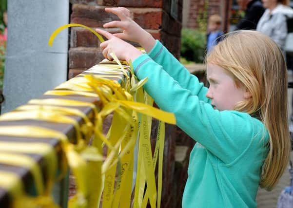Molly ties a yellow ribbon in memory of her Nana Kathy Crook.