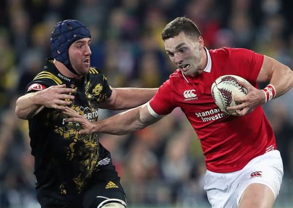 British and Irish Lions' George North is tackled by Hurricanes' Mark Abbott