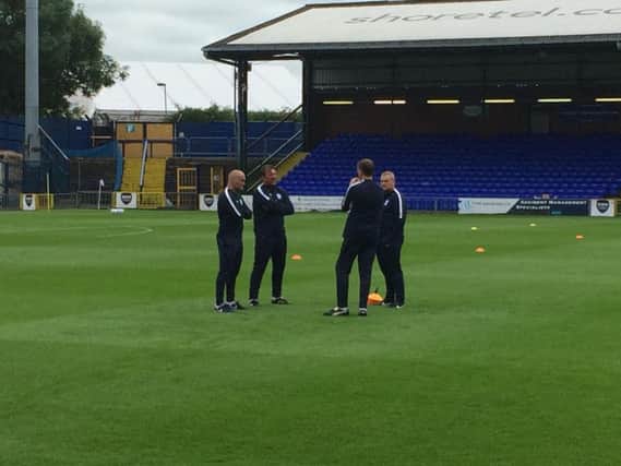 Alex Neil and his staff talk tactics ahead of the game at Edgeley Park.