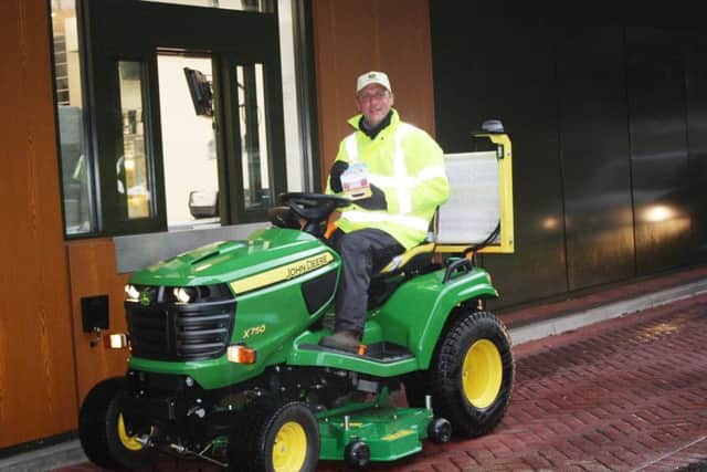 Andy Maxfield is trying to break the world record by travelling from John O'Groats to Land's End on a lawnmower. Pictures is Andy at the drive through McDonald's at Preston Docks