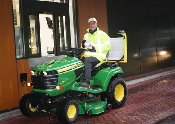 Andy Maxfield is trying to break the world record by travelling from John O'Groats to Land's End on a lawnmower. Pictures is Andy at the drive through McDonald's at Preston Docks