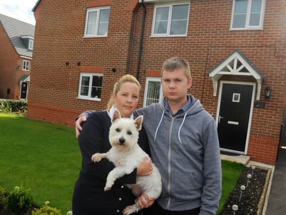 Homeowner Laura Tomlinson, partner Andrew Seed and dog Lexie, outside their home a new housing estate in Leyland.