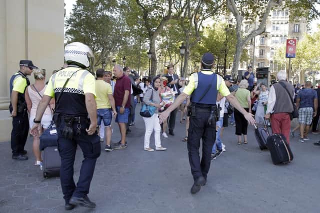 Police officers tell members of the public to leave the scene in a street in Barcelona, Spain