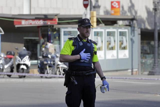 A police officer cordons off a street in Barcelona after a van crashed on a pavement in the city's historic Las Ramblas district, injuring several people (AP)