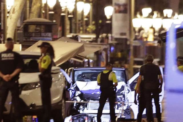 Police officers stand next to the van involved on an attack in Las Ramblas, Barcelona