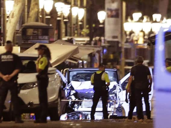 Police officers stand next to the van involved on an attack in Las Ramblas, Barcelona