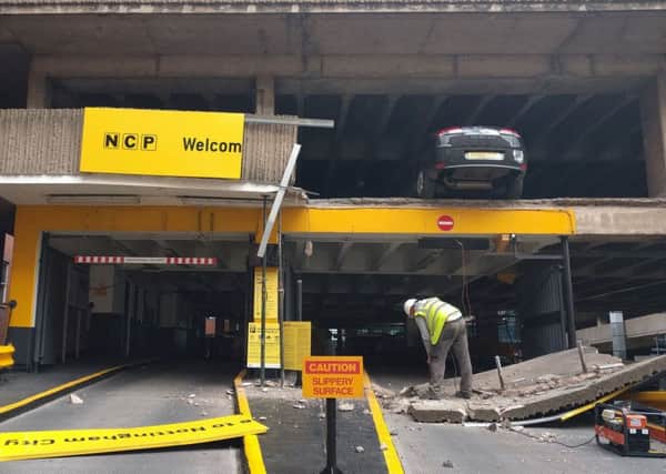A car park in Nottingham after a wall collapsed leaving vehicles hanging in mid-air.
