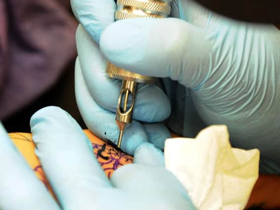 Tattoos release microscopic pigment particles