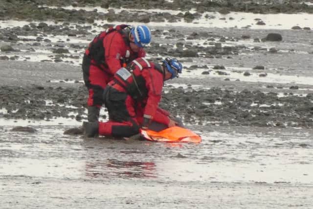 Rescuers free the woman's leg from the quicksand after she became trapped.