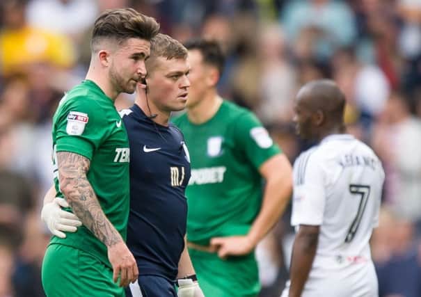 Sean Maguire is helped off by PNE physio Matt Jackson at Fulham