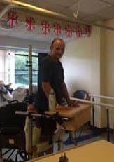 Phil Woodford having physio in the gym learning to stand up again after his stroke