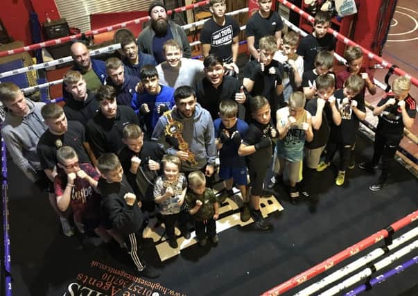 Jack Catterall (centre) shows off his British title belt to youngsters at Jennings Gym