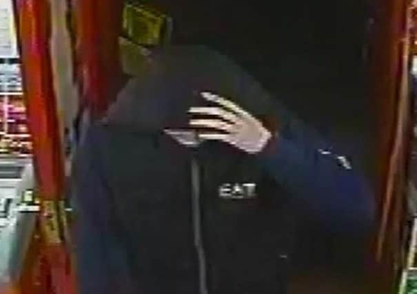 Police are seeking a man in connection with a robbery at Booze Busters