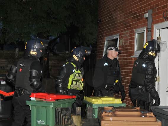 Officers in protective gear carry out a dawn raid on a house in the Brookfield area of Preston and arrest one man.