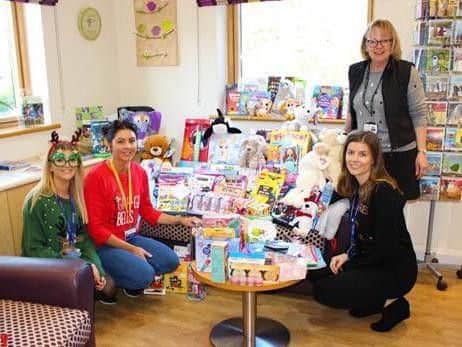 Danielle Buchan, Utiligroups HR director, hands over a sackload of gifts and toys to Derian House