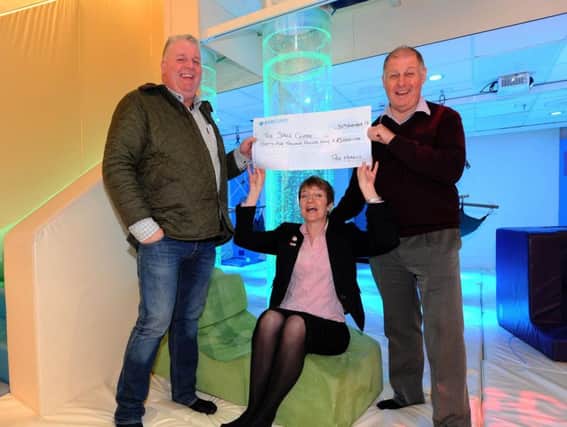 Peter Marquis, left, handing over the cheque to Andrea Baker and David Diggins from the Space Centre.