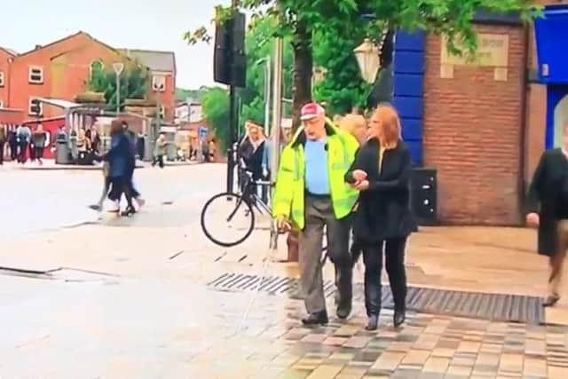 Bob Mills, of Galloway's, showing Abbie Jones, BBC North West Tonight reporter, how difficult it is to cross the shared space in Preston