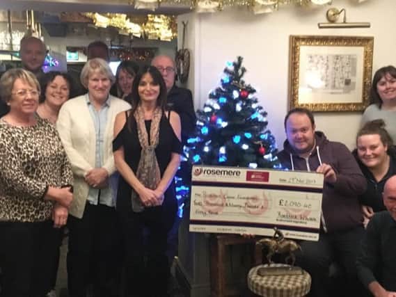 Terry Trelfa, Simon Hunter, Chris Warton, Rob Coirrigan, Linda Hall, Helen Quinn, Margaret Corrigan, Julie Simmons and Brenda Trelfa. Right of the tree are Andy and Steph Hardman with the cheque for Rosemere, Shelley and Andy Dawes and Neil Bamford