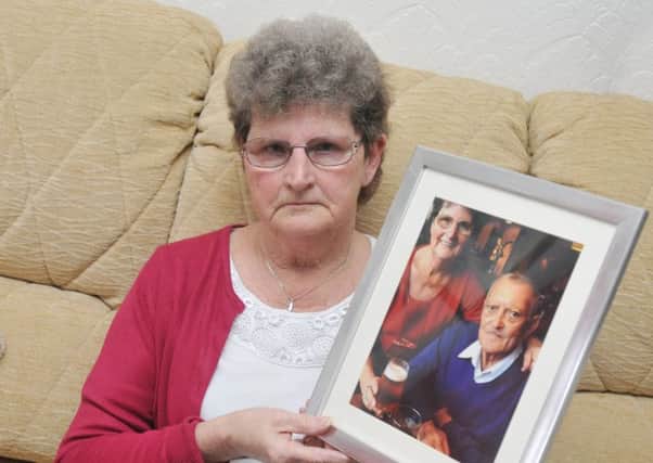 LANCASTER 18-12-17
Widow Marlene Reid, with a photograph herself and late husband Bob - she was upset when she visited Bob's grave to find gravediggers had covered it with a box of soil.