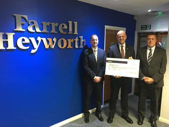 John French, Farrell Heyworth financial services director, John Shellcross (holding the cheque) and finance director John Collins.