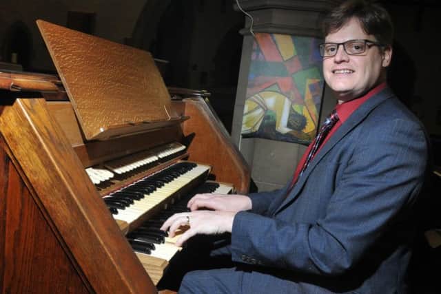 Mark Leadbeater at the church organ, which needs urgent restoration work