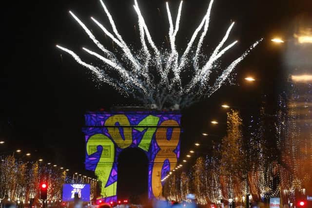 A firework explodes over the Arc de Triomphe as part of the New Year celebrations on the Champs Elysees, in Paris, France