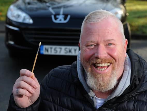 Carl Marshall, 50, from Euxton, with one of the tiny paintbrushes he uses to paint thousands of stars which twinkle at night in bedrooms all over the UK