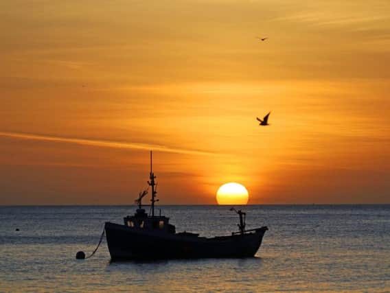 A fishing boat anchored as the sun rises