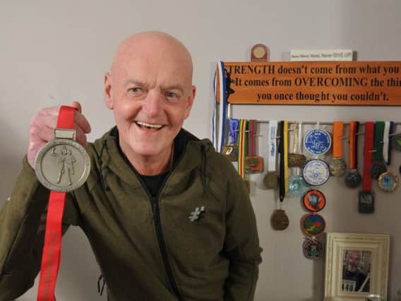 Graham Vickers at home with his running medals