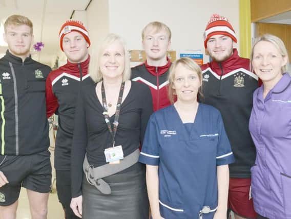 Wigan Warriors youth players, from the left, Joe Brown, Nathan Reidy, Sam Grant and Declan ODonnell are greeted by Rosemere Cancer Centre Ribblesdale Ward's Rebecca Biltcliffe, Dr Alison Birtle and lead chemotherapy nurse Joanne Wilkinson on their mission to cheer patients on behalf of Helen Duchamp and dad Mick Brakewell