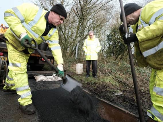 County Coun Keith Iddon (right) watches as a pothole is repaired