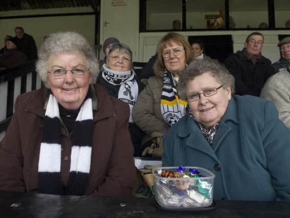 Chorley FC supporter Rita Charnley, 83, left, on the terraces with her trademark  box of sweets
