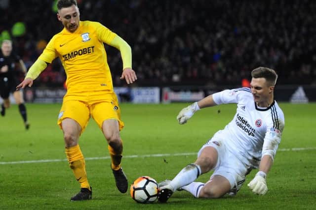 Preston North End's Louis Moult is tackled by Sheffield United's Simon Moore
