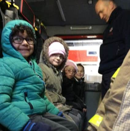 OLSE reception class pupils try out the cbain of the fire engine