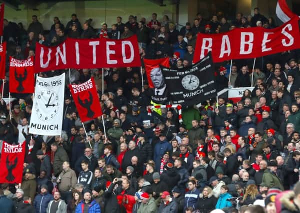 Fans hold banners in the stands in tribute to the Munich air disaster victims
