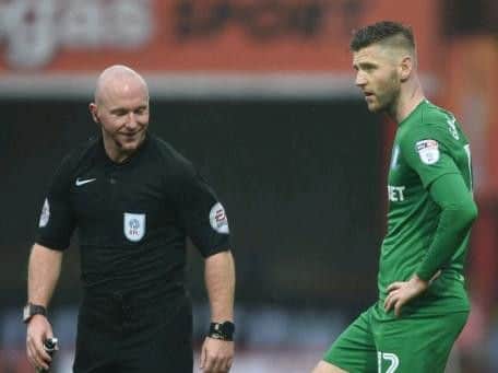 PNE midfielder Paul Gallagher with referee Simon Hooper at Brentford