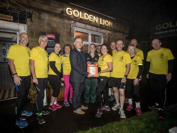 The Lions running community with their new defibrillator which is at the Golden Lion Pub, Higher Wheelton.
Pictured are Shelby Williams and Kevin Garvey - area sales manager for Cardiac Science