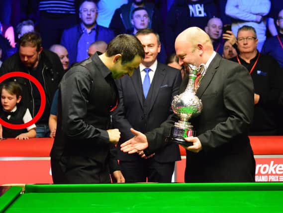 Ronnie O'Sullivan celebrating his win at Preston Guild Hall, before giving his medal to a young boy in the crowd (circled). Photo: Michael Ellison