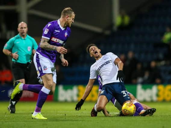 Callum Robinson feels the force of a Bolton challenge.