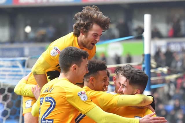 Sean Maguire is mobbed after scoring PNE's third goal at Bolton