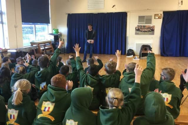 Schoolchildren line up to ask Tom a question