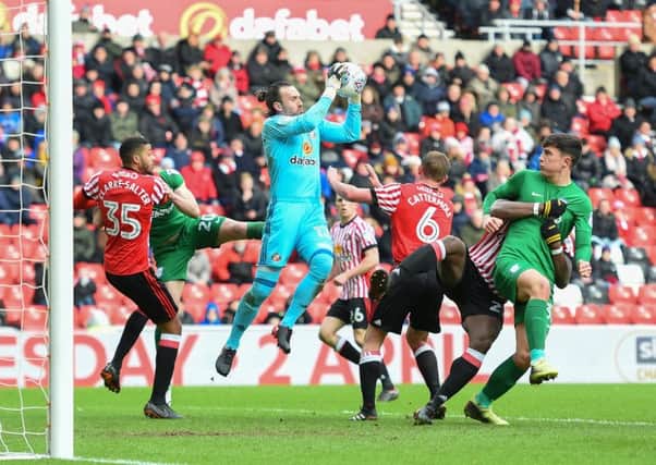 Sunderland goalkeeper Lee Camp gathers a cross as Josh Earl (right) and Ben Davies challenge