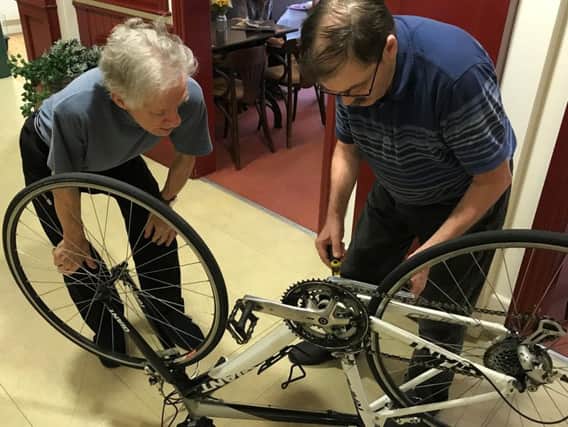 Stephen Baylis and John Bossom working to fix bikes donated by Hewitt Cycle at The Lodge, in Buckshaw Retirement Village