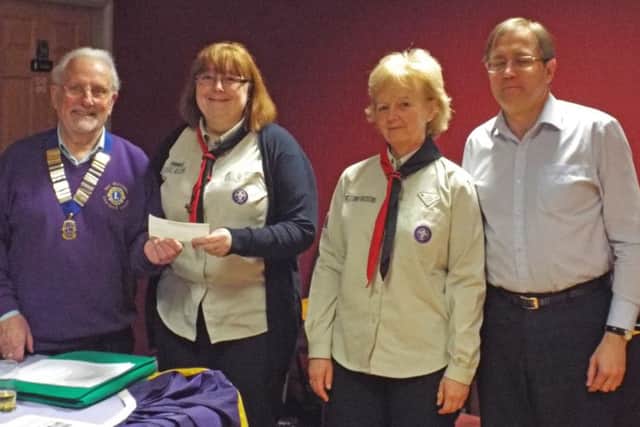 Leyland and Cuerden Valley Lion President Mal Williams presents a cheque to The 9th Penwortham Scouts, represented by Carol Singleton, Lindsey Wilson and Chris Teague.