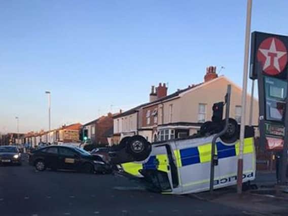 A police van on its roof after colliding with a vehicle on Cemetery Road in Southport on Sunday